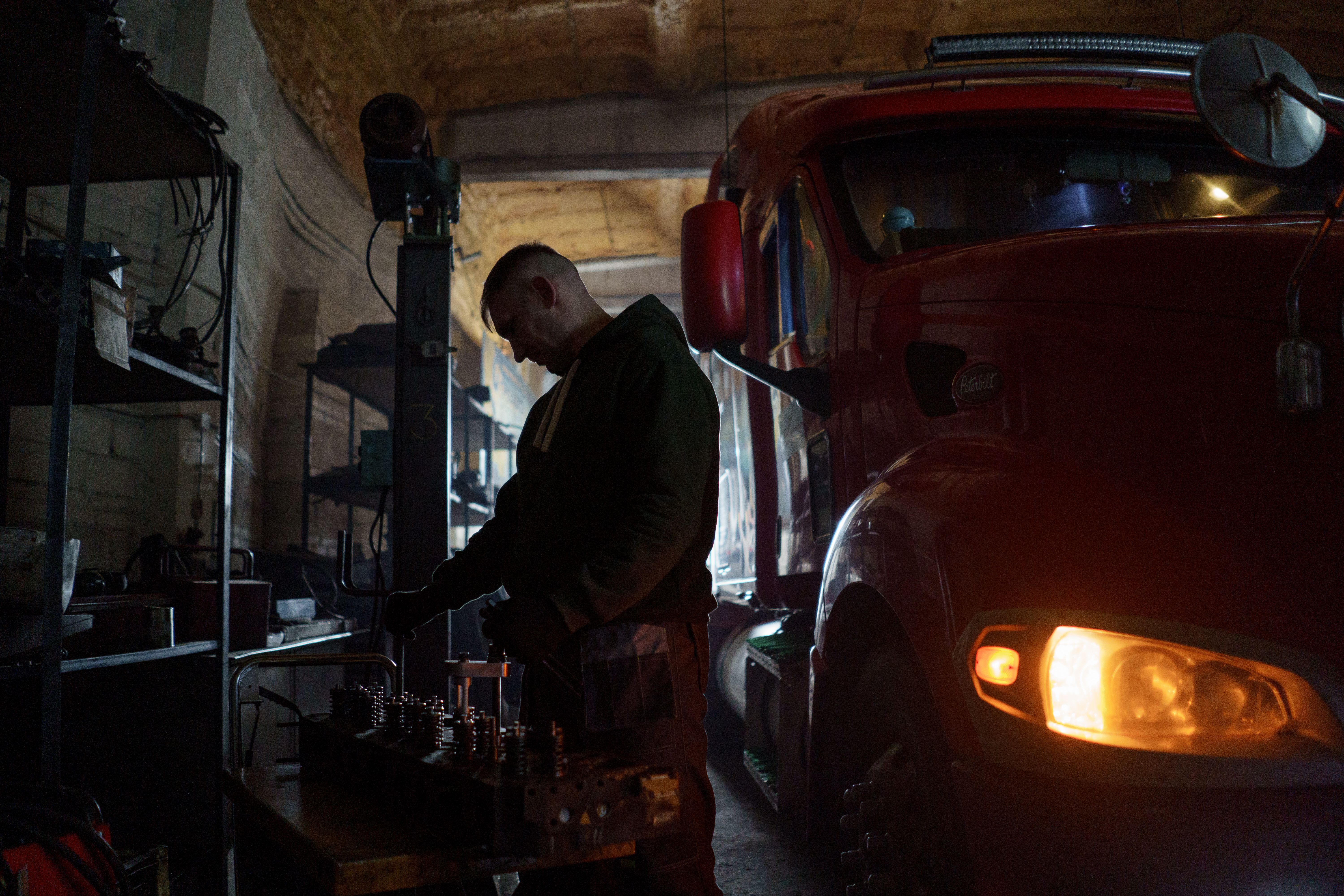 Mechanic beside a commercial truck in a workshop