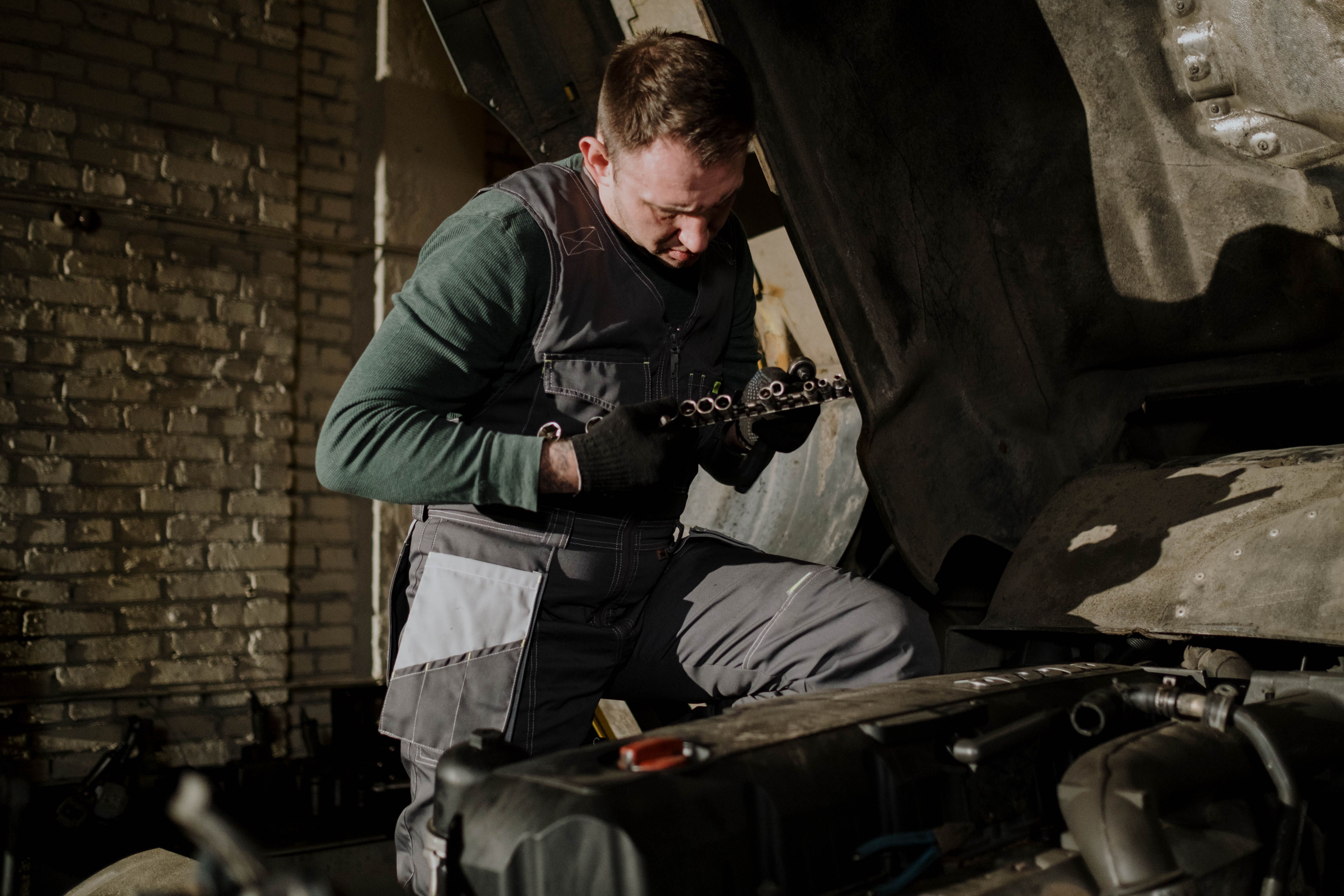 Mechanic working beside a truck engine