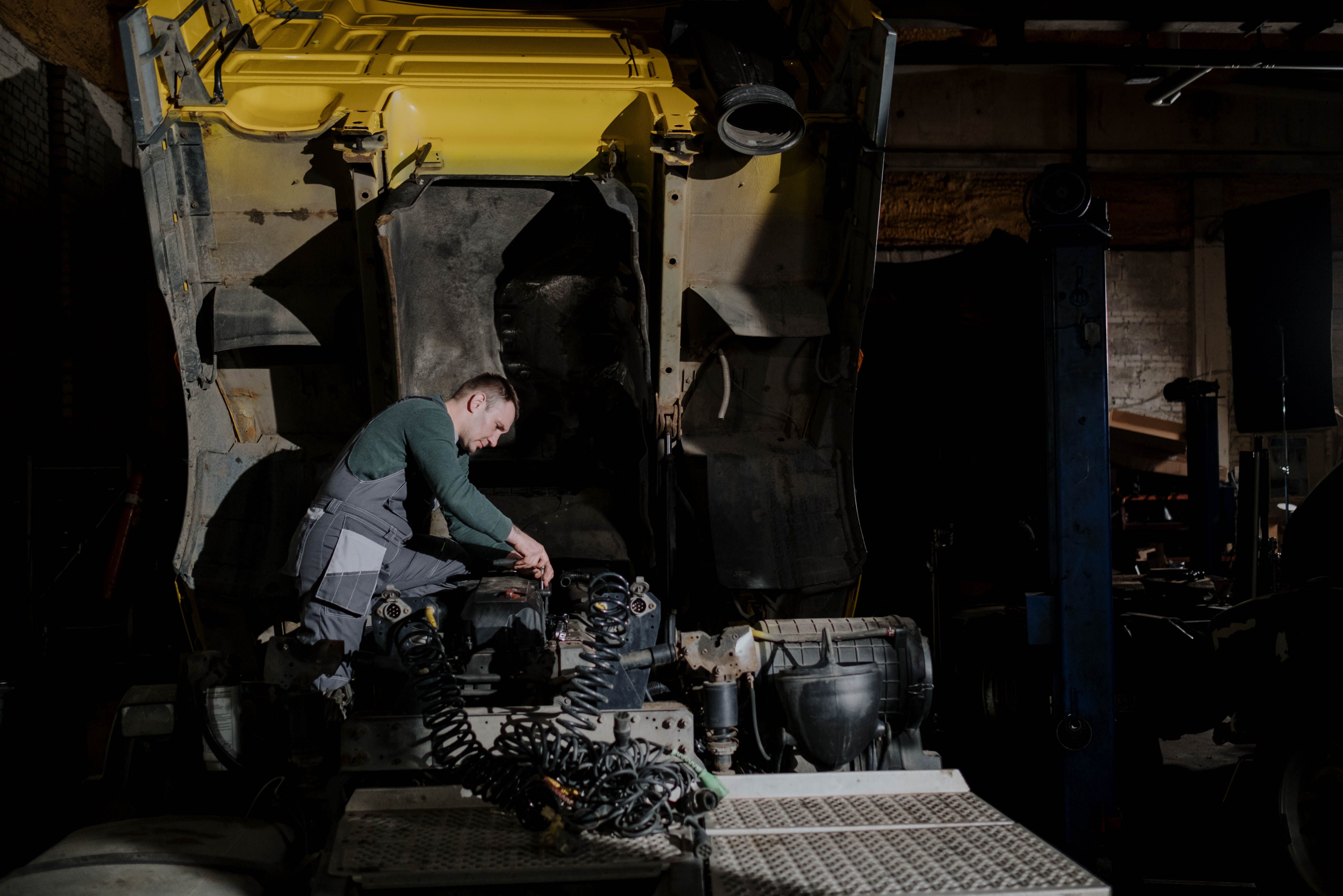 Mechanic working at the raised cab of a commercial truck