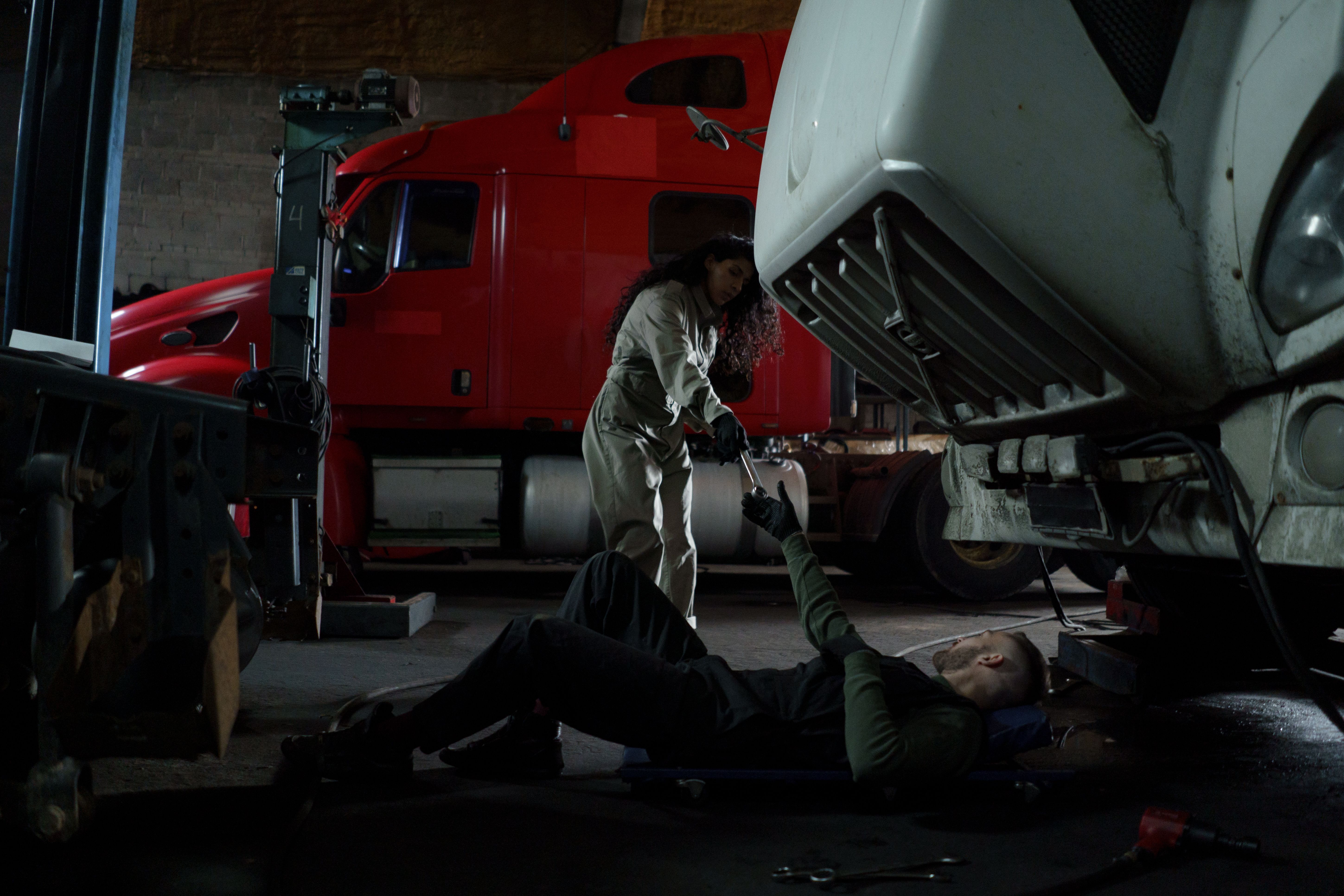 Technicians servicing commercial trucks in a workshop